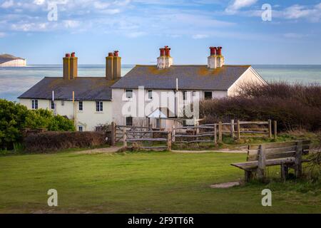 Blick auf die Klippen der Seven Sisters und die Cottages der Küstenwache von Seaford Head über den Fluss Cuckmere. Seaford, Sussex, England, Vereinigtes Königreich.