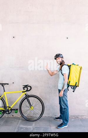 Porträt eines jungen Mannes, der mit einem Kurier Lebensmittel nach Hause liefert. Stockfoto
