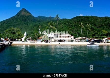 VILA DO ABRAÃO, ILHA GRANDE, RIO DE JANEIRO, BRASILIEN - 10. APRIL 2011: Panoramablick auf das Dorf von einem Boot aus. Dahinter die Berge und der Dschungel. Stockfoto