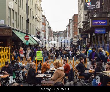 London, Großbritannien. April 2021. Belebte Restaurants und Bars in der Old Compton Street, Soho.mehrere Straßen im Zentrum von London wurden zu bestimmten Tageszeiten für den Verkehr gesperrt, um Sitzplätze im Freien in Bars und Restaurants zu ermöglichen. Kredit: Vuk Valcic/SOPA Images/ZUMA Wire/Alamy Live Nachrichten Stockfoto