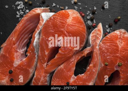 Frisches, rohes Lachssteak mit Gewürzen, zubereitet zum Grillen oder Braten. Gesunde Meeresfrüchte. Stockfoto