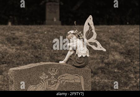 Süße weibliche Engelsfigur auf einem Grabstein Stockfoto