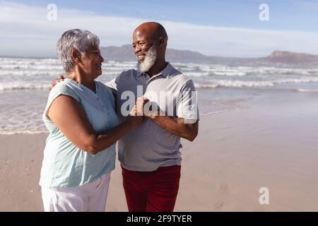Glückliches älteres afroamerikanisches Paar, das sich gegenseitig umarmt Strand Stockfoto