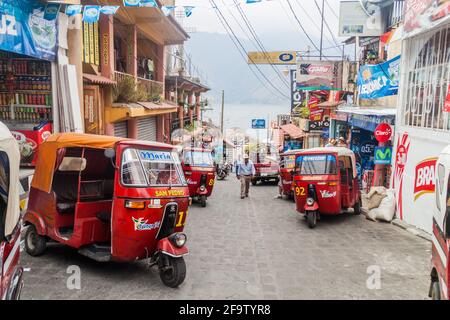 SANTIAGO ATITLAN, GUATEMALA - 24. MÄRZ 2016: Reihe von Tuk Tuks auf einer Straße im Dorf Santiago Atitlan. Stockfoto