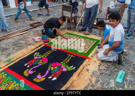 ANTIGUA, GUATEMALA - 25. MÄRZ 2016: Menschen schmücken Osterteppiche in Antigua Guatemala-Stadt, Guatemala Stockfoto