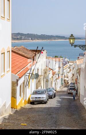 Steile Straße, die zur Küste in Lagos führt, einer historischen Stadt und beliebtes Touristenziel an der Algarve im Südwesten Portugals, im Sommer Stockfoto