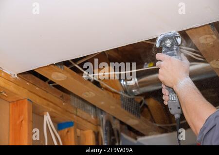 Mann schneiden Gipskarton Trockenbau mit Winkel Hand elektrische Energie Werkzeuge Stockfoto