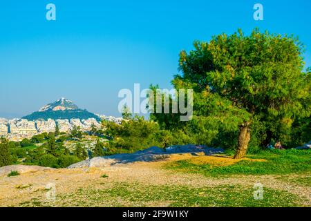 ATHEN, GRIECHENLAND, 10. DEZEMBER 2015: Die Menschen picknicken auf dem Philipoppou-Hügel mit Blick auf den Lycabetus-Hügel in Athen Stockfoto