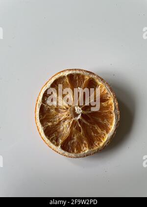 Draufsicht auf eine sonnengetrocknete Scheibe Orange auf weißem Hintergrund Stockfoto