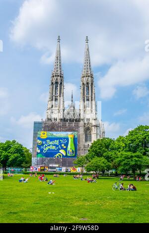 WIEN, ÖSTERREICH, JUNI 2016: Auf einer Liegewiese vor der votivkirche in Wien genießen die Menschen einen sonnigen Tag. Stockfoto