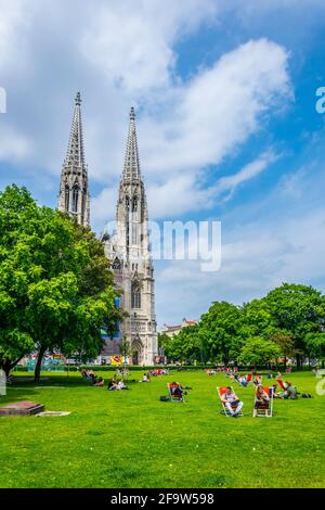 WIEN, ÖSTERREICH, JUNI 2016: Auf einer Liegewiese vor der votivkirche in Wien genießen die Menschen einen sonnigen Tag. Stockfoto
