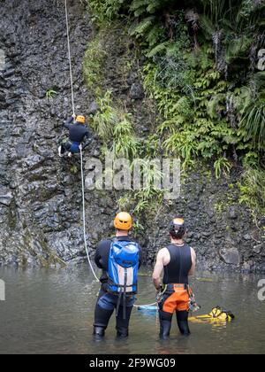 AUCKLAND, NEUSEELAND - 18. Apr 2021: Blick auf Abseillehrer an den Kitekite Falls, Piha, Auckland Stockfoto