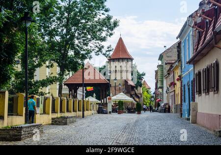 SIBIU, RUMÄNIEN, 6. JULI 2015: Nicht identifizierte Menschen wandern entlang der mittelalterlichen Verteidigungsmauer und des Schreinerturms in Sibiu, Region Siebenbürgen, Stockfoto