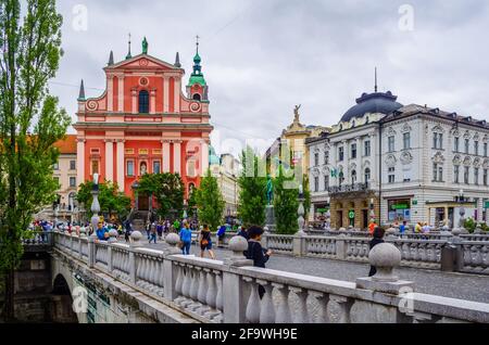 LJUBLJANA, SLOWENIEN, 29. JULI 2015: Die Menschen überqueren den Fluss Ljubljanica auf der Dreifachbrücke (Tromostovje) in Richtung Preseren-Platz und Franc Stockfoto