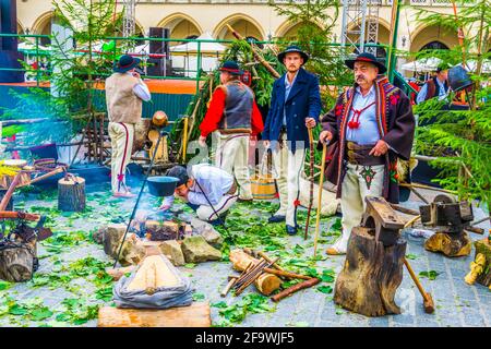 KRAKAU, POLEN, 11. AUGUST 2016: Eine Gruppe polnischer Menschen in Nationalkostümen auf dem Hauptplatz von Krakau/Krakau. Stockfoto