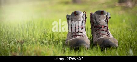 Wanderschuhe im Wald. Ruhen Sie sich nach einem langen Trekking-Spaziergang aus. Gesunder Lebensstil in der Natur. Stockfoto