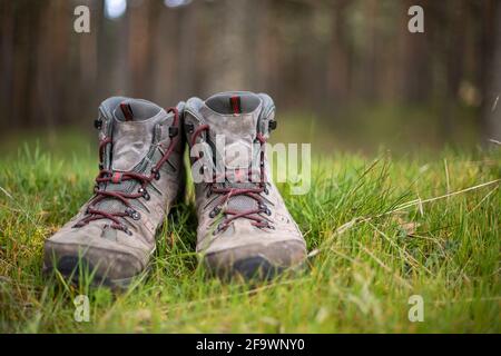 Wanderschuhe im Wald. Ruhen Sie sich nach einem langen Trekking-Spaziergang aus. Gesunder Lebensstil in der Natur. Stockfoto