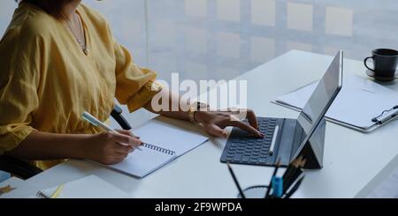 Asian Business Frau arbeitet mit Tablet im Büro. Work from Home Konzept. Stockfoto