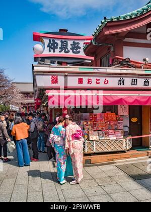 25. März 2019: Tokio, Japan - Besucher, darunter zwei junge Frauen in Kimonos, auf dem Markt auf dem Gelände des buddhistischen Senso-ji-Tempels in Asakusa... Stockfoto