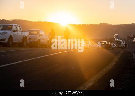 Zwei Surfer, die während eines Sonnenaufgangs in pichilemu punta de lobos chile zum Meer wandern Stockfoto