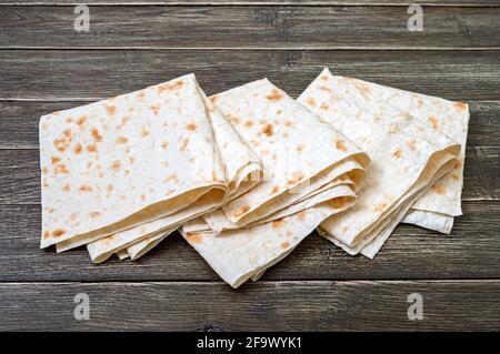 Frisch gebackenes armenisches Fladenbrot Lavasch. Dünnes Pita-Brot auf Holzhintergrund. Stockfoto