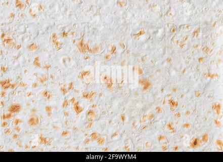 Armenisches und türkisches ungesäuertes Fladenbrot, Nahaufnahme. Strukturierter Lavaschurgrund. Textur aus dünnem, traditionell frisch gebackenem, hausgemachtem orientalischem Brot. Stockfoto