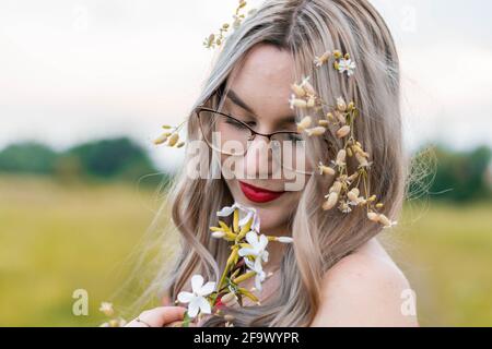 Alles wacht auf und der Frühling beginnt. Mädchen auf einer Wiese, mit Blumen in den Händen. Es war Frühlingstag und wir beschlossen, Fotos mit meinem Freund zu machen. Stockfoto