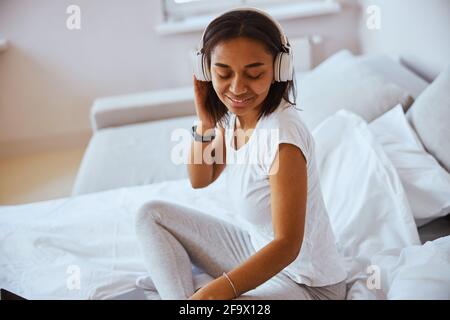 Schöne afroamerikanische Frau, die zu Hause Musik hört Stockfoto