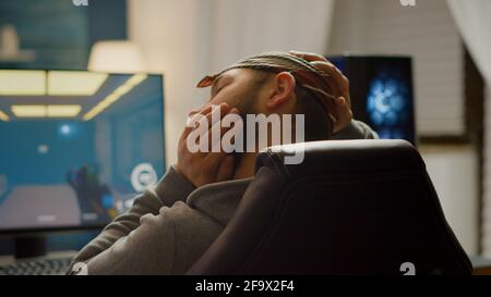 Rückansicht Aufnahme von professionellen Gamer spielen in Ego-Shooter Online-Videospiel auf leistungsstarken Computer. Virtuelle Meisterschaft im Cyberspace, eSport Spieler während Gaming-Turnier durchführen. Stockfoto