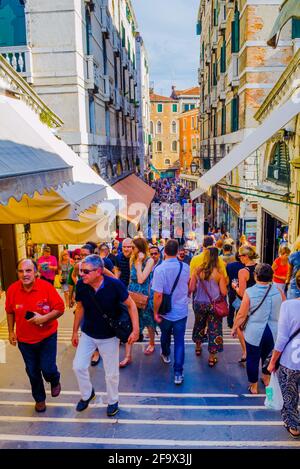 VENEDIG, ITALIEN, 20. SEPTEMBER 2015: Menschen, die zwischen Souvenirläden und Ständen auf der Rialtobrücke vorbeiziehen - eine der berühmten und beliebten Sehenswürdigkeiten mit Touris Stockfoto