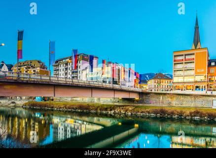 VILLACH, ÖSTERREICH, 20. FEBRUAR 2016: Blick auf eine Brücke über die drau mit Turm der nikolaikirche in villach, österreich. Stockfoto