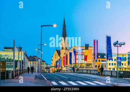 VILLACH, ÖSTERREICH, 20. FEBRUAR 2016: Blick auf eine Brücke über die drau mit Turm der nikolaikirche in villach, österreich. Stockfoto