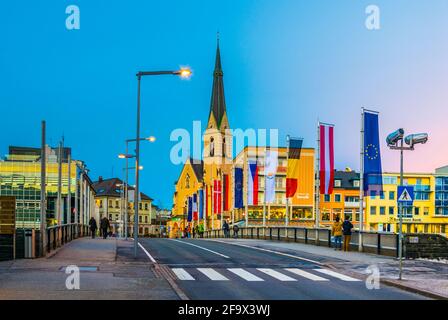 VILLACH, ÖSTERREICH, 20. FEBRUAR 2016: Blick auf eine Brücke über die drau mit Turm der nikolaikirche in villach, österreich. Stockfoto