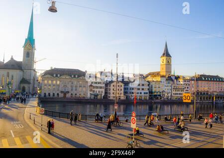 ZÜRICH, SCHWEIZ, 25. OKTOBER 2015: Zürcher Innenstadt und Fraumünster im Herbst in der Schweiz. Auf einem Kai des limmat fahren Menschen vorbei Stockfoto