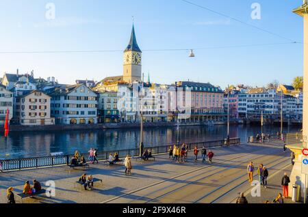 ZÜRICH, SCHWEIZ, 25. OKTOBER 2015: Zürcher Innenstadt und Fraumünster im Herbst in der Schweiz. Auf einem Kai des limmat fahren Menschen vorbei Stockfoto