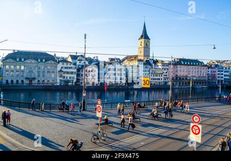 ZÜRICH, SCHWEIZ, 25. OKTOBER 2015: Zürcher Innenstadt und Fraumünster im Herbst in der Schweiz. Auf einem Kai des limmat fahren Menschen vorbei Stockfoto