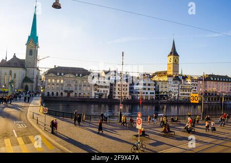 ZÜRICH, SCHWEIZ, 25. OKTOBER 2015: Zürcher Innenstadt und Fraumünster im Herbst in der Schweiz. Auf einem Kai des limmat fahren Menschen vorbei Stockfoto