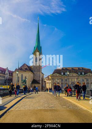 ZÜRICH, SCHWEIZ, 24. OKTOBER 2015: An sonnigen Herbsttag überqueren die Menschen die Brücke vor dem grossmünster in zürich Stockfoto