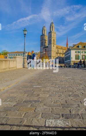 ZÜRICH, SCHWEIZ, 24. OKTOBER 2015: An sonnigen Herbsttag überqueren die Menschen die Brücke vor dem grossmünster in zürich Stockfoto