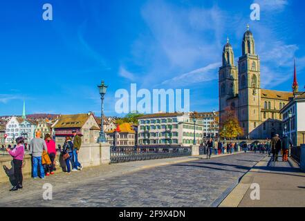 ZÜRICH, SCHWEIZ, 24. OKTOBER 2015: An sonnigen Herbsttag überqueren die Menschen die Brücke vor dem grossmünster in zürich Stockfoto