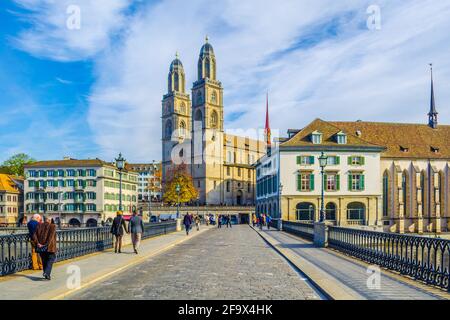 ZÜRICH, SCHWEIZ, 24. OKTOBER 2015: An sonnigen Herbsttag überqueren die Menschen die Brücke vor dem grossmünster in zürich Stockfoto