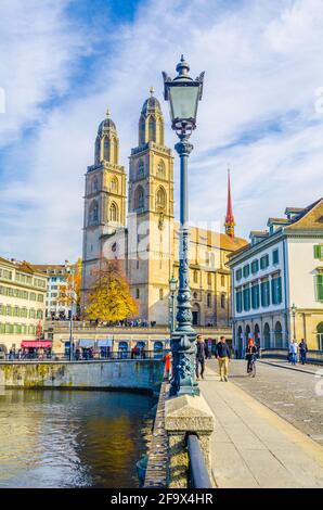ZÜRICH, SCHWEIZ, 24. OKTOBER 2015: An sonnigen Herbsttag überqueren die Menschen die Brücke vor dem grossmünster in zürich Stockfoto