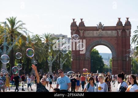 BARCELONA, SPANIEN - 08. JUNI 2019: Menschen, die Spaß haben und Seifenblasen für Kinder in der Nähe des Triumphbogens oder Arco de Triunfo machen Stockfoto