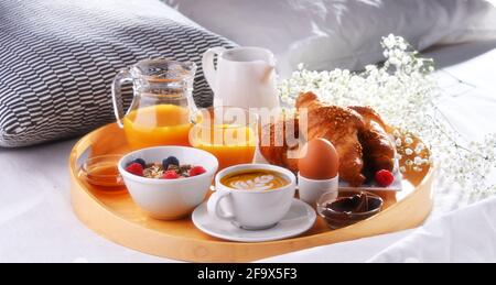 Ein Tablett mit Frühstück auf einem Bett in einem Hotelzimmer. Stockfoto