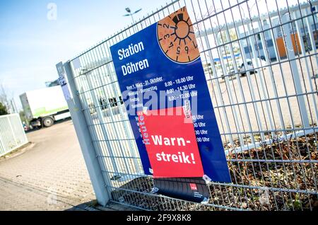 21. April 2021, Niedersachsen, Hannover: Ein Plakat mit der Aufschrift „Warnstreik“ hängt an einem Schild am Eingang zu einem TÜV Nord-Gelände im Landkreis Döhren. Vor dem Hintergrund der Tarifverhandlungen hat die Gewerkschaft Verdi zu einem „taeglichen@-Home-Streik“ aufgerufen. Verdi beklagt, dass die Mitarbeiter sich um Sicherheitstests von Corona Atemschutzmasken kümmern, trotz Infektionsgefahr Fahrtests in beengten Autos durchführen oder die Sicherheit von Kernkraftwerken unter schwierigen Bedingungen gewährleisten, dafür aber nicht ausreichend bezahlt werden. Foto: Hauke-Christian Dittrich/dpa Stockfoto