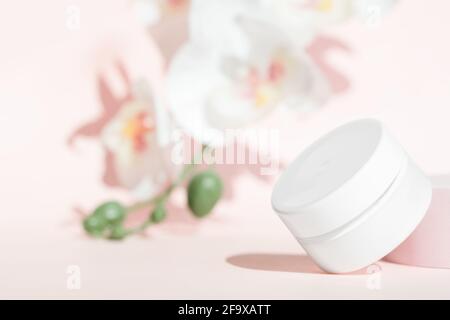 Kosmetische Creme Glas Produkt Mockup auf floralem rosa Hintergrund. Stockfoto