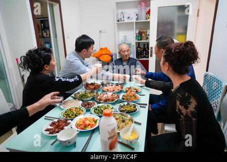 (210421) -- URUMQI, 21. April 2021 (Xinhua) -- Niu Jiashan (3., L) feiert am 26. Februar 2021 mit seiner Familie zu Hause in Urumqi, der Autonomen Region Xinjiang Uygur im Nordwesten Chinas, das Laternenfest. Eine Karriere-Staffel von drei Generationen über 70 Jahre innerhalb derselben Familie hat die erstaunliche Entwicklung des Eisenbahnverkehrs in der Autonomen Region Xinjiang Uygur im Nordwesten Chinas erlebt. Xinjiang ist seit jeher bekannt für seine raue geologische und klimatische Umgebung, die von riesigen Wüsten, schneebedeckten Bergen, verheerenden Winden bis hin zu salzigen Sümpfen reicht, die alle natürliche Enemien sind Stockfoto