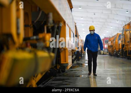 (210421) -- URUMQI, 21. April 2021 (Xinhua) -- Niu Ruiqing überprüft am 3. März 2021 den Zustand der Ausrüstung in der Instandhaltungsabteilung für Gleise und Maschinen in Urumqi, der Autonomen Region Xinjiang Uygur im Nordwesten Chinas. Eine Karriere-Staffel von drei Generationen über 70 Jahre innerhalb derselben Familie hat die erstaunliche Entwicklung des Eisenbahnverkehrs in der Autonomen Region Xinjiang Uygur im Nordwesten Chinas erlebt. Xinjiang ist seit jeher bekannt für seine raue geologische und klimatische Umgebung, die von riesigen Wüsten, schneebedeckten Bergen, verheerenden Winden bis hin zu salzigen Sümpfen reicht, alle von ihnen nat Stockfoto