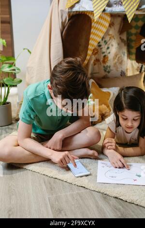 Junge und Mädchen spielen Schatzsuche Spiel in einem Zelt Zu Hause Stockfoto