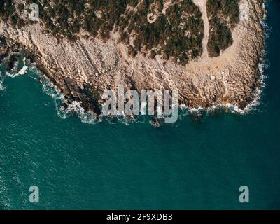 Große Wellen übergreifen die unglaublichen Felsen der Ägäis auf der Halbinsel Pelion, Griechenland. Foto mit Drohne aufgenommen. Stockfoto